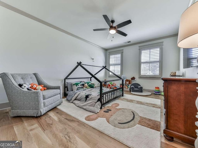 bedroom featuring crown molding, ceiling fan, and wood-type flooring