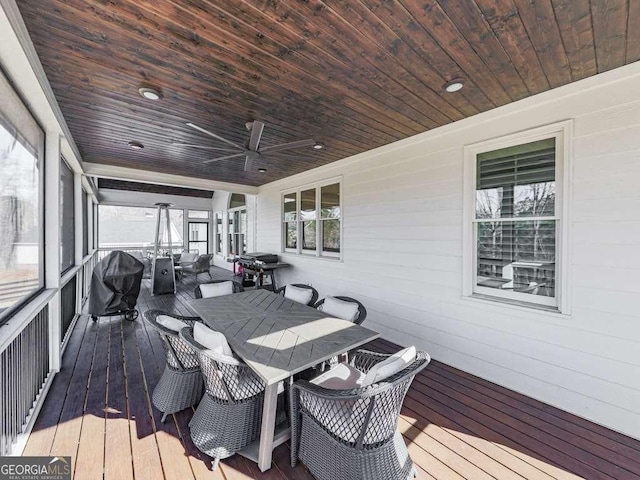 wooden deck with grilling area and ceiling fan