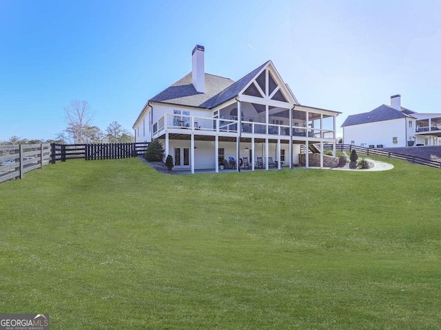 back of property featuring a wooden deck and a yard