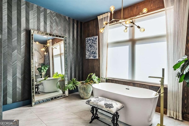 bathroom featuring a notable chandelier and a bathtub