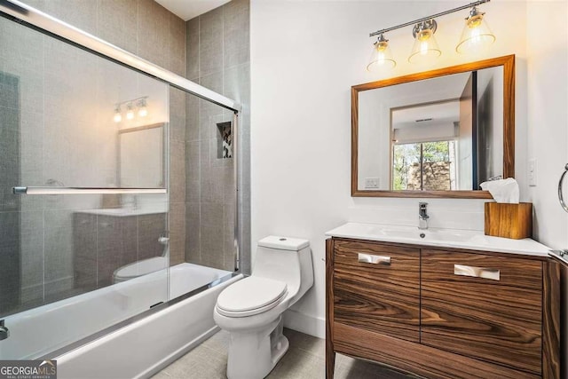 full bathroom featuring vanity, shower / bath combination with glass door, and toilet