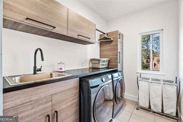 washroom featuring sink, light tile patterned floors, washing machine and dryer, and cabinets