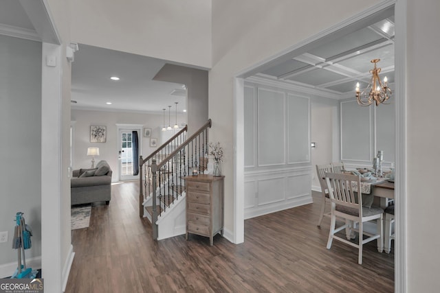 interior space with an inviting chandelier, crown molding, coffered ceiling, and hardwood / wood-style flooring