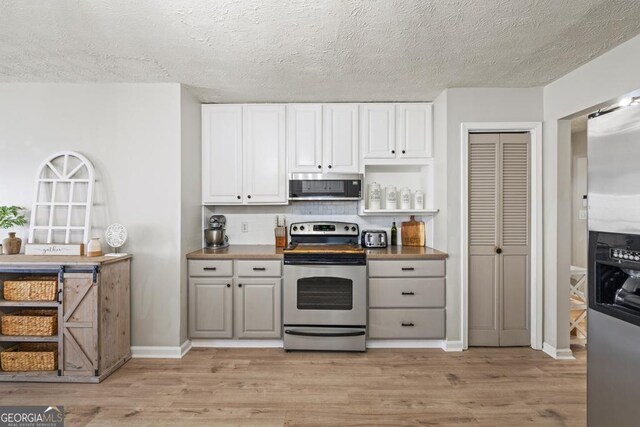 kitchen with sink, stainless steel dishwasher, white cabinets, and light wood-type flooring