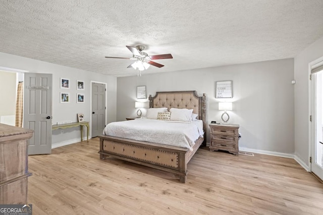 bedroom featuring ceiling fan, light hardwood / wood-style flooring, and a textured ceiling