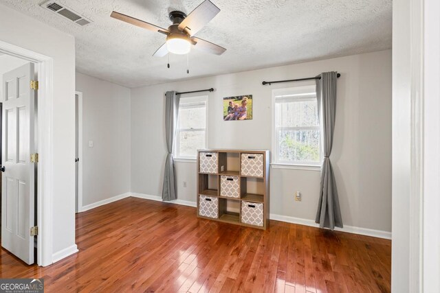 interior space with ceiling fan, dark hardwood / wood-style floors, and a textured ceiling