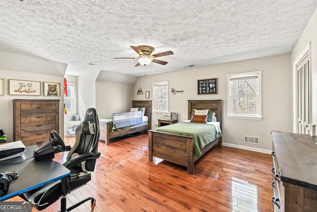 bedroom with wood-type flooring, a closet, and a textured ceiling