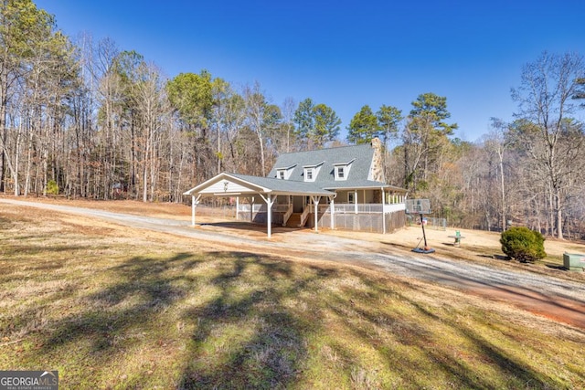 farmhouse-style home featuring a front yard, a carport, and a porch