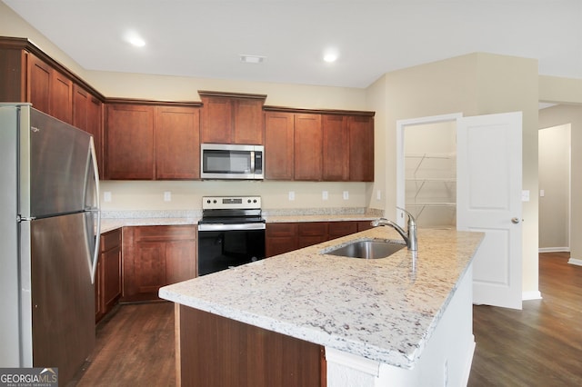 kitchen with sink, dark wood-type flooring, a kitchen island with sink, stainless steel appliances, and light stone countertops