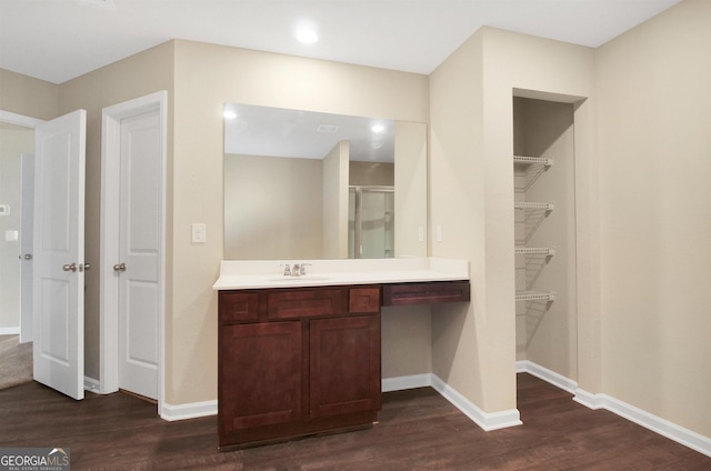 bathroom with hardwood / wood-style flooring, vanity, and an enclosed shower