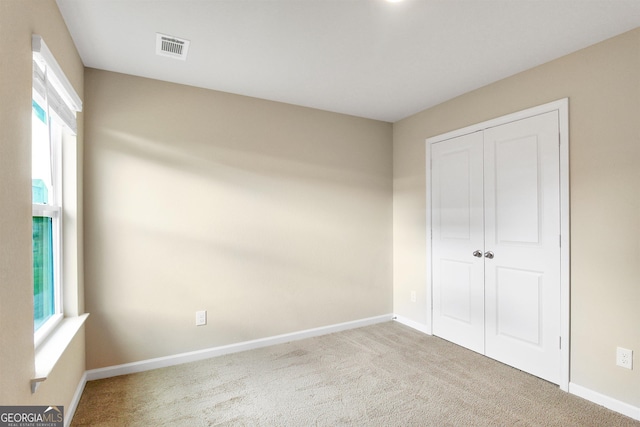 unfurnished bedroom with carpet floors and a closet