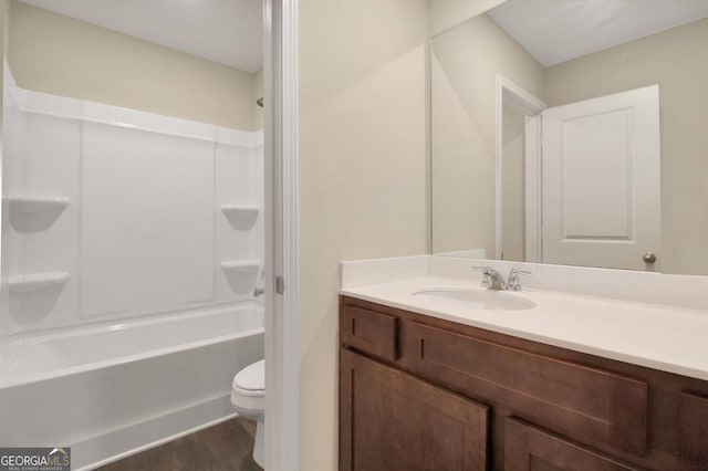 full bathroom with hardwood / wood-style flooring,  shower combination, vanity, and toilet