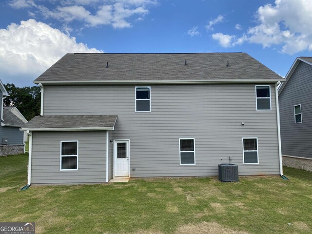 back of house with a yard and central AC