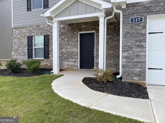 view of exterior entry with a yard