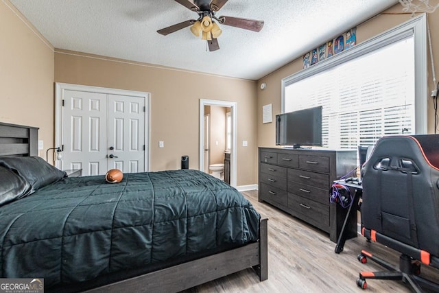 304 Stathams Way, Warner Robins, GA 31088 - bedroom with light wood finished floors, a textured ceiling, connected bathroom, a closet, and a ceiling fan