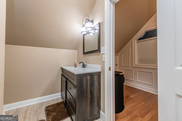 304 Stathams Way, Warner Robins, GA 31088 - bathroom with vanity, wood finished floors, lofted ceiling, and baseboards