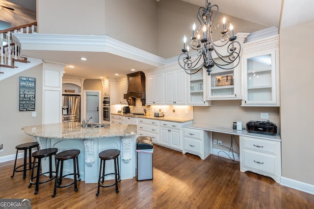 304 Stathams Way, Warner Robins, GA 31088 - kitchen featuring stainless steel appliances, premium range hood, a kitchen bar, white cabinetry, and dark wood-style flooring