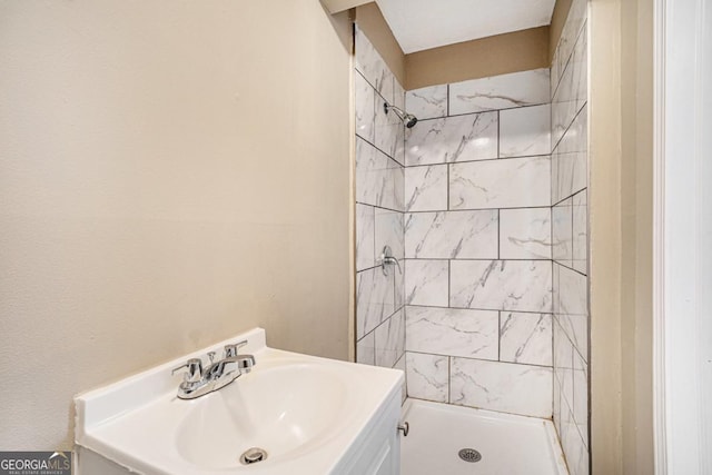 bathroom featuring vanity and tiled shower