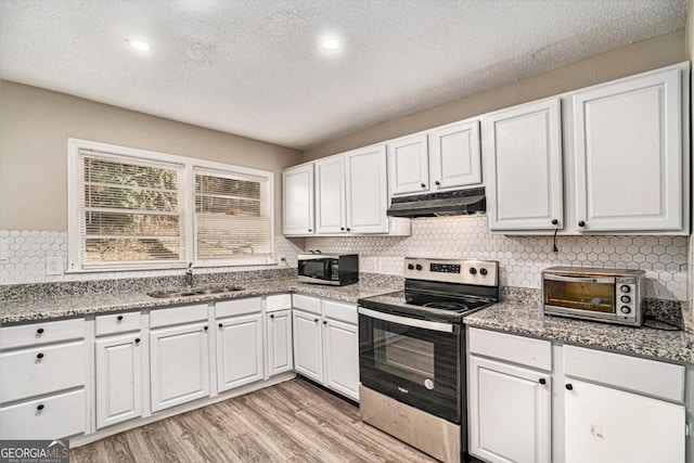 kitchen with sink, stainless steel electric range, white cabinetry, backsplash, and light wood-type flooring