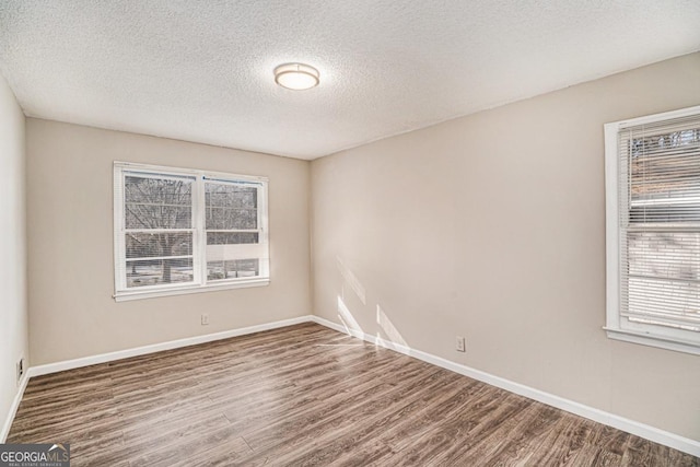 spare room featuring hardwood / wood-style floors and a textured ceiling