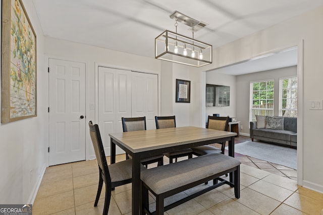 dining area featuring light tile patterned floors and a chandelier