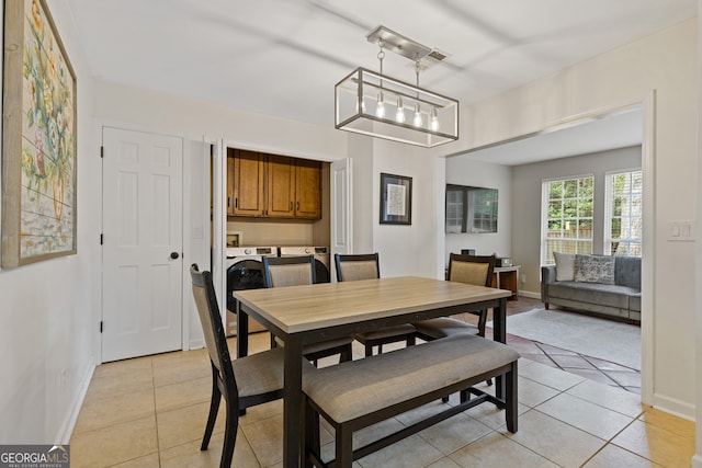 tiled dining space featuring washer and clothes dryer