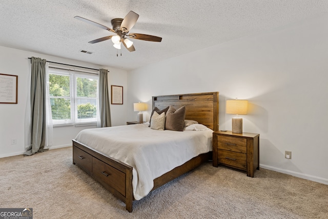 bedroom featuring ceiling fan, light carpet, and a textured ceiling