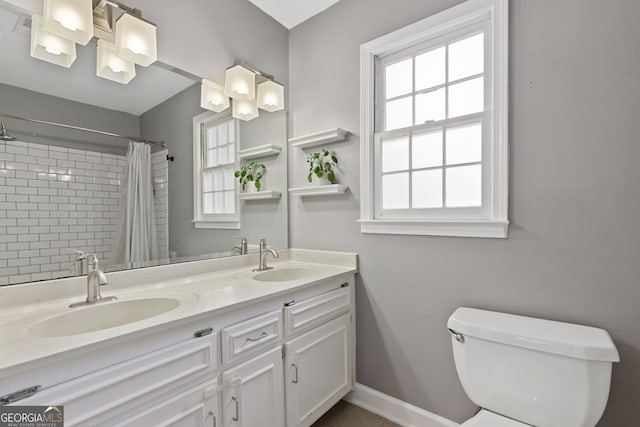 bathroom with vanity, plenty of natural light, curtained shower, and toilet