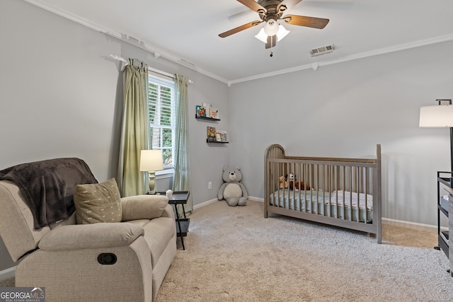 bedroom with crown molding, ceiling fan, a nursery area, and light carpet