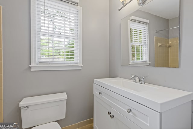 bathroom featuring vanity, plenty of natural light, a shower, and toilet