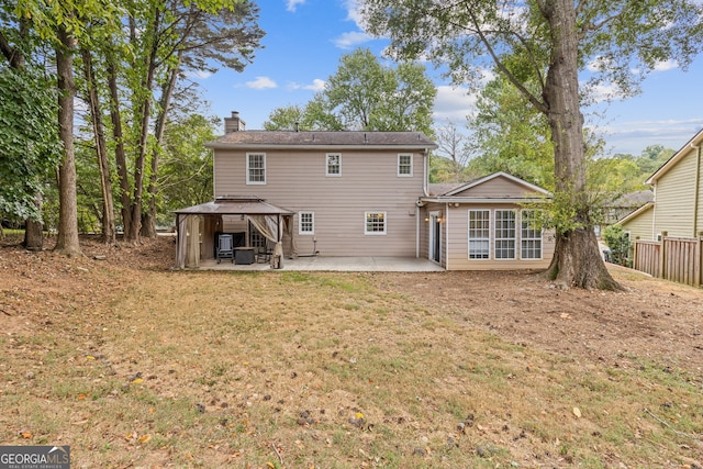 back of property featuring a gazebo, a patio area, and a lawn