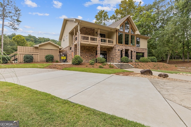 view of front of property featuring a front lawn and a balcony