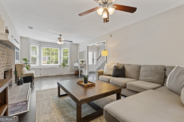 living room with ceiling fan, hardwood / wood-style floors, and a fireplace