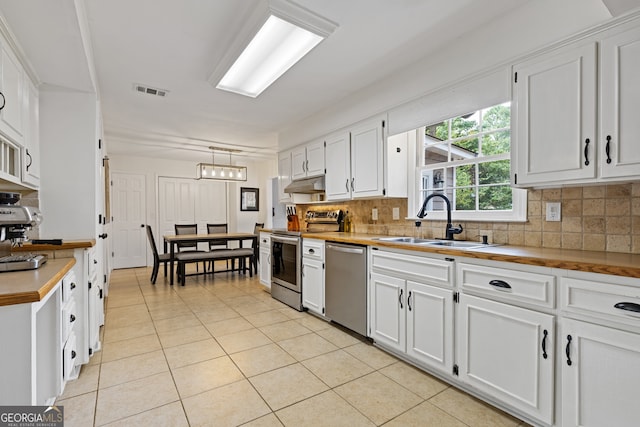 kitchen featuring white cabinetry, appliances with stainless steel finishes, sink, and decorative light fixtures