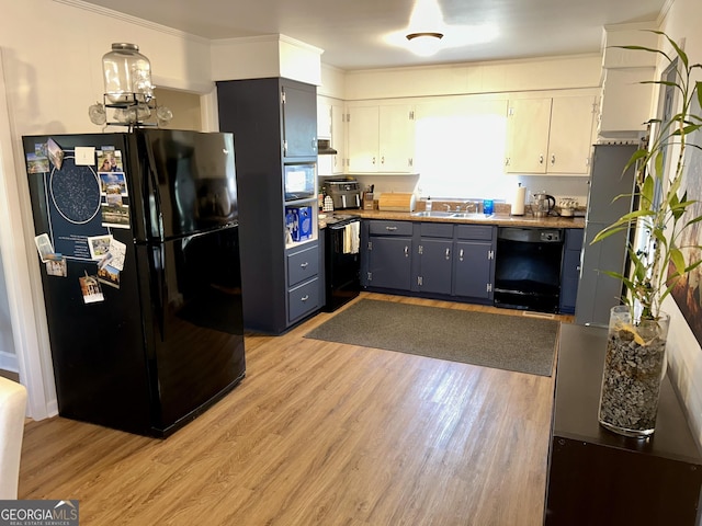 kitchen featuring crown molding, black appliances, white cabinets, blue cabinets, and light wood-type flooring