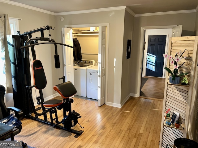 exercise room with separate washer and dryer, light hardwood / wood-style flooring, and ornamental molding