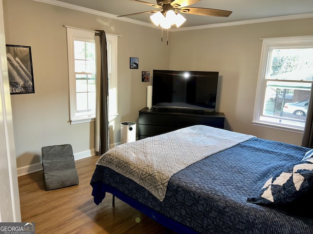 bedroom featuring crown molding, wood-type flooring, and ceiling fan