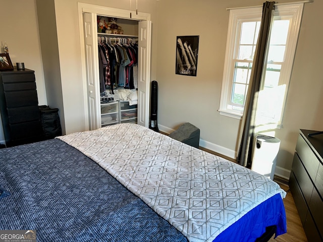 bedroom with dark hardwood / wood-style floors and a closet