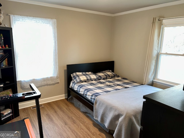 bedroom featuring ornamental molding and hardwood / wood-style floors