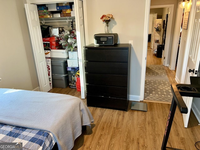 bedroom with light hardwood / wood-style floors and a closet