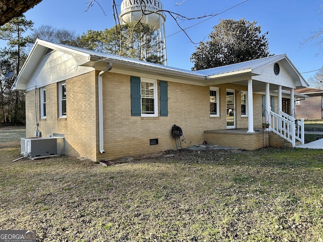 view of front of property featuring covered porch, a front lawn, and central air condition unit