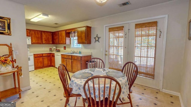 kitchen featuring sink, white appliances, and a textured ceiling