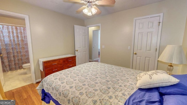 bedroom with ceiling fan, light wood-type flooring, and ensuite bath