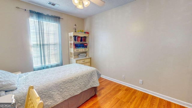 bedroom with a textured ceiling and light hardwood / wood-style floors