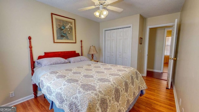 bedroom with ceiling fan, hardwood / wood-style flooring, a closet, and a textured ceiling