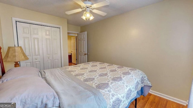 bedroom with hardwood / wood-style flooring, ceiling fan, and a closet