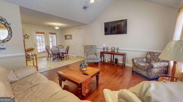 living room with wood-type flooring and vaulted ceiling