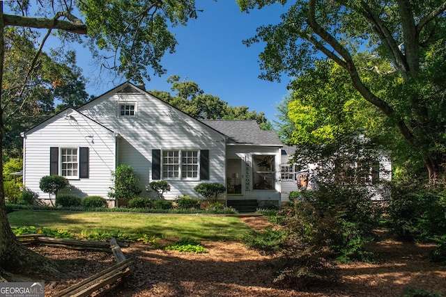 rear view of property featuring a lawn