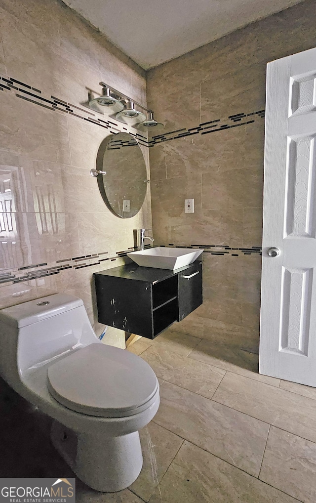 bathroom featuring vanity, toilet, and tile walls