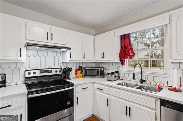 kitchen featuring white cabinetry, sink, decorative backsplash, and stainless steel appliances